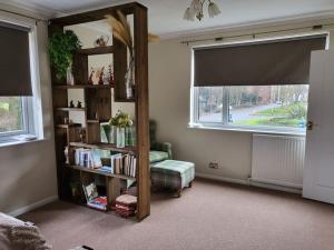 een woonkamer met een boekenplank en een raam bij The Barbers in Beverley