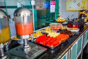 サルバドールにあるHotel Piramide Pituba - Rua Pernambucoのキッチンのカウンターに並べられたビュッフェ形式の料理