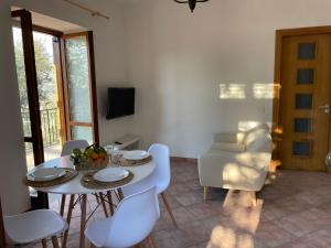 uma sala de jantar com uma mesa branca e cadeiras brancas em SKY VIEW Villa em Piano di Sorrento