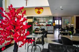 un restaurante con mesas, sillas y flores rojas en Hotel Piramide Pituba - Rua Pernambuco en Salvador