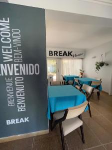 a conference room with blue tables and chairs and a sign at Panorama Villa Gesell in Villa Gesell