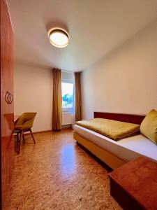 um quarto com uma cama, uma mesa e uma janela em TheCrossing Bed & Breakfast em Hausen im Tal