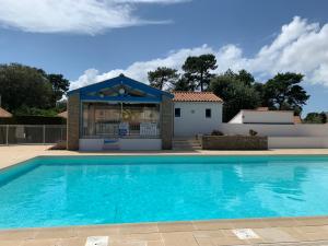 una piscina di fronte a una casa di Magnifique Maison forêt & Mer avec piscine - Wifi a Saint-Jean-de-Monts