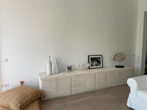 a white living room with a white couch and a cabinet at Cap Sa Sal suites -Apartament Begur - Costa Brava in Begur