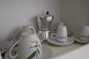 una encimera con tazas y platos blancos y una cafetera en Residence Prestige, en Gorgonzola