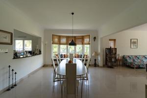 a dining room and living room with a table and chairs at Luho 206 in Bangalore