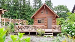 a wooden cabin with a porch and a bridge at Sudomari no Yado Sunmore - Vacation STAY 46742v in Nikko