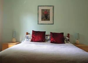 a bedroom with a large bed with red pillows at Notter Mill in Landrake