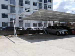 a parking lot with cars parked under a canopy at Apartamento cerca parque del Café con Piscina in Montenegro