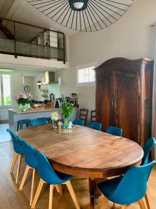 une salle à manger avec une table en bois et des chaises bleues dans l'établissement VILLA PRESENCE - Chambres d'hôtes - Activités bien-être, à Toulon