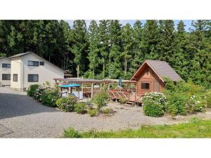 une maison avec une terrasse couverte et une cour ornée de plantes dans l'établissement Sudomari no Yado Sunmore - Vacation STAY 46754v, à Nikkō