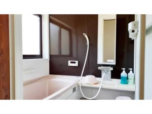 La salle de bains est pourvue d'une baignoire, d'un lavabo et d'un miroir. dans l'établissement Sudomari no Yado Sunmore - Vacation STAY 46754v, à Nikkō