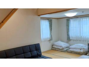 uma sala de estar com um sofá e uma cama em Sudomari no Yado Sunmore - Vacation STAY 46748v em Nikko
