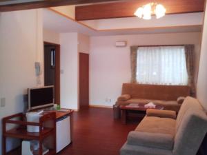 a living room with a couch and a tv at Sudomari no Yado Sunmore - Vacation STAY 46748v in Nikko
