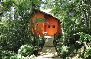 una pequeña casa naranja en medio de árboles en Villa Flor Ecoresort, en Nova Petrópolis