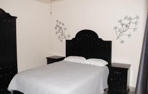 a bedroom with a white bed with two pillows at Playas Hotel Suites in Puerto Peñasco