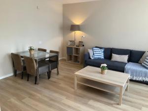 ein Wohnzimmer mit einem Sofa und einem Tisch in der Unterkunft Fisherman's House by Hofstad Hotels in Scheveningen