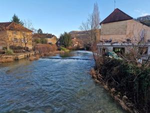 einen Fluss in einer Stadt mit Häusern und Gebäuden in der Unterkunft L'Atelier 57 - Votre meublé authentique ! in Arbois