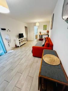 un soggiorno con divano rosso e tavolo di Cozy apartment in centric area at caleta de fuste with Air Conditioner a Caleta De Fuste