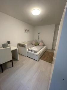 uma sala de estar branca com um sofá e uma secretária em Appartment Relax&Easy em Karlsruhe