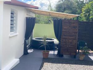a patio with a pergola and a table and a bench at Un jour ailleurs in Saint-Pierre