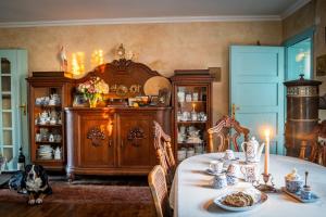 a dining room with a table with a dog sitting at it at Gościniec Bocianowo - oaza ciszy i spokoju wśród alpak in Stręgiel
