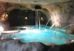 uma banheira de hidromassagem numa gruta com uma cascata em Turismo Rural & SPA El Cercado em Bérchules