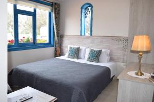 a bedroom with a bed and two windows at La Casa Azul in Cuenca