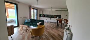sala de estar con sofá verde y mesa en Villa Azzurra immersa nel Verde tra Firenze, Arezzo e Siena, en Terranuova Bracciolini