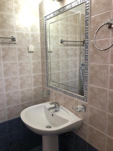 a bathroom with a sink and a mirror at Gaia Apartments By Villa Kokkoni in Marathokampos