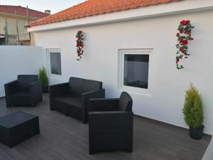 a patio with black chairs and christmas wreaths on a white wall at Casa de Praia Daniel in Lavra