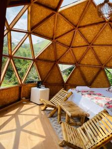 a room with a bed and chairs in a yurt at Ecofuratena Glamping & Experience in Utica