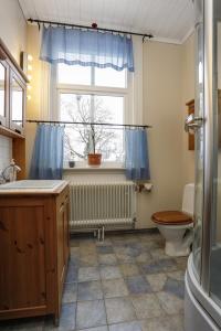 ein Bad mit einem Waschbecken, einem WC und einem Fenster in der Unterkunft HagbackensGård Bed&Breakfast in Örebro