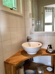 La salle de bains est pourvue d'un lavabo blanc et d'un miroir. dans l'établissement Annehill i Bro, à Bro