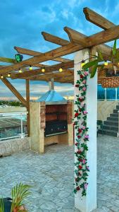 a stone patio with a fireplace and a wooden pergola at Hotel Dubaird in Santo Domingo