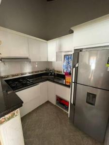 a kitchen with white cabinets and a stainless steel refrigerator at Apto. en zona céntrica con vista panorámica al pueblo in San Gil