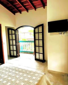 a room with two doors and a tv on the wall at Suítes Ilhabela in Ilhabela +46 photos