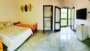 a bedroom with a bed and a tv in it at Suítes Ilhabela in Ilhabela