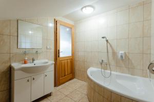 a bathroom with a tub and a sink and a bath tub at Orava Hotel in Vitanová