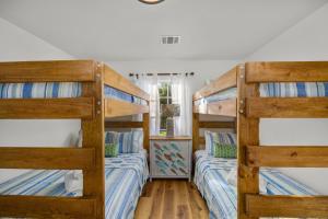 two bunk beds in a room with wooden floors at SeabrookNook 3min2Beach Kemah Boardwalk NASA in Seabrook