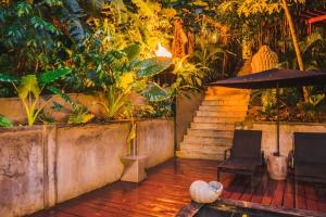 a patio with two chairs and an umbrella and stairs at Saboga Lodge in Saboga