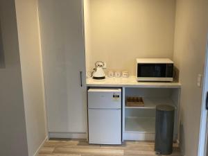 a small kitchen with a microwave and a small refrigerator at Cambridge Te Awa Rivertrail BnB in Cambridge