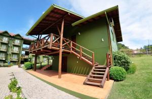 un edificio verde con una escalera lateral en Villa Flor Ecoresort, en Nova Petrópolis