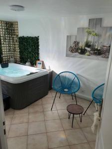 埃奇昂普拉奇的住宿－Maison avec Jacuzzi privatif et terrasse N’1，一间带两把椅子和浴缸的浴室