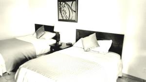 a black and white photo of a bedroom with two beds at Shoreside Inn & Suites in Wabamun