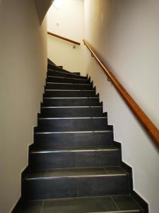 a staircase with black steps and a wooden rail at Ferienwohnung Meta Fischerhude in Ottersberg