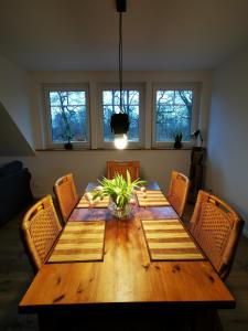a dining room table with chairs and a vase on it at Ferienwohnung Meta Fischerhude in Ottersberg
