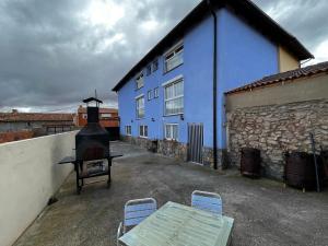 a blue building with a table and chairs in front of it at Casa Rural Maroto in Campillo