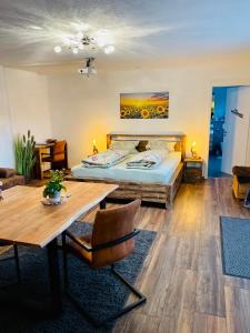 1 dormitorio con cama, mesa y sidra de mesa en Sonnenberg Resort, en Elzach