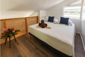 a bedroom with a large white bed with flowers on it at Vaiahi Tiny Home N1377 DTO-MT in Bora Bora